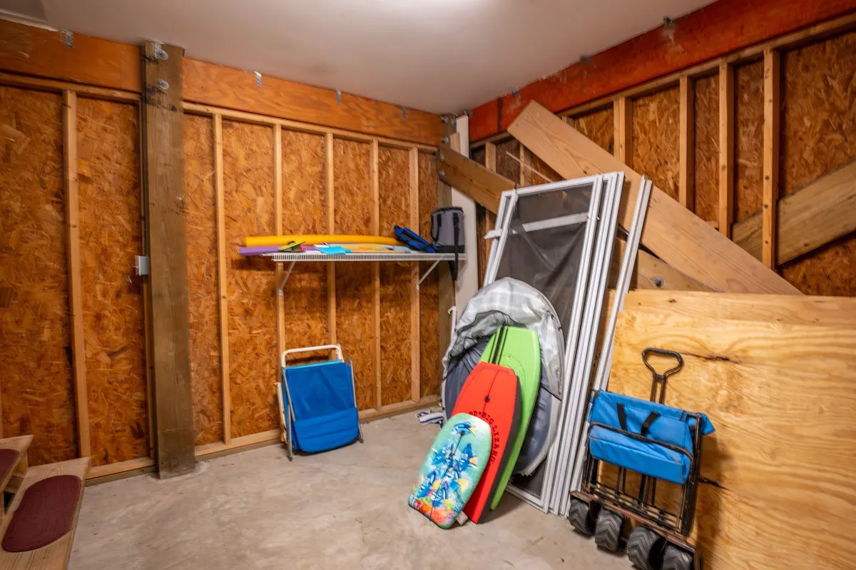 This image displays colorful surfboards, stacked beach chairs, and a shelf with various items, all organized in a practical, accessible space. The surfboards and beach equipment hint at outdoor adventures and exploration.